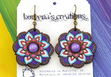 Primarily purple flower mandala earrings on rainbow background