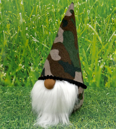 White bearded gonk with camo pattern fabric on a grass background