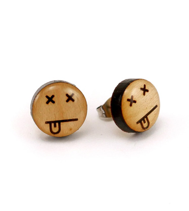Close up of wooden stud earrings with an expired face
