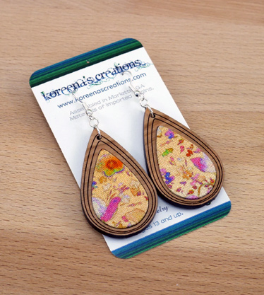 Product shot of teardrop shaped fabric and wood earrings on display card