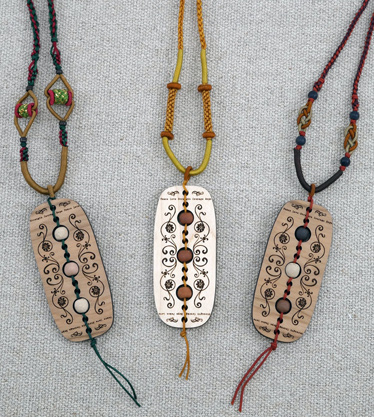 Three oval shaped engraved wood pendants with three spinner beads