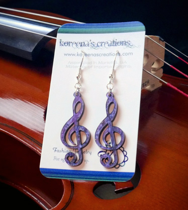 Laser cut acrylic treble clef earrings displayed on a viola