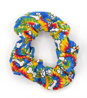 Scrunchie with a bright tie dye pattern with  white pawprints and bones